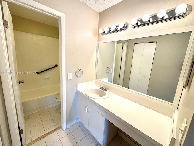 bathroom with tile patterned flooring, vanity, a textured ceiling, and toilet