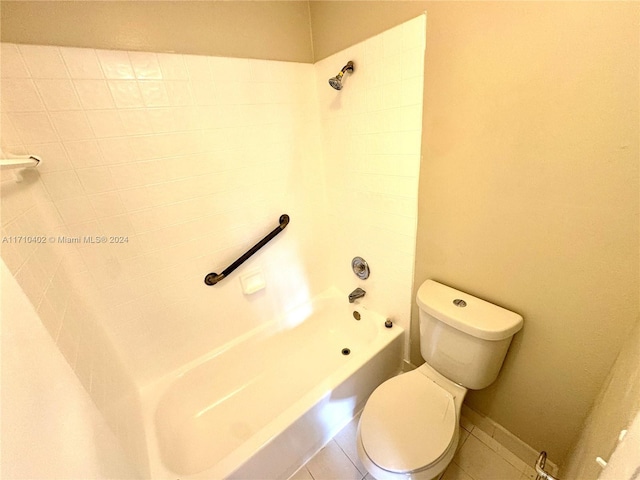 bathroom with tile patterned flooring, toilet, and tiled shower / bath