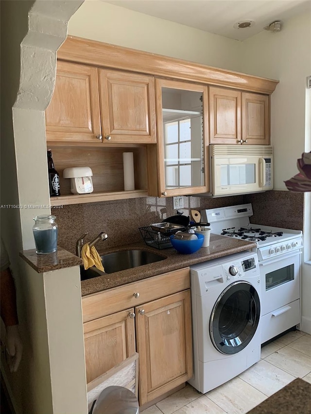 kitchen with washer / clothes dryer, sink, dark stone counters, and white appliances