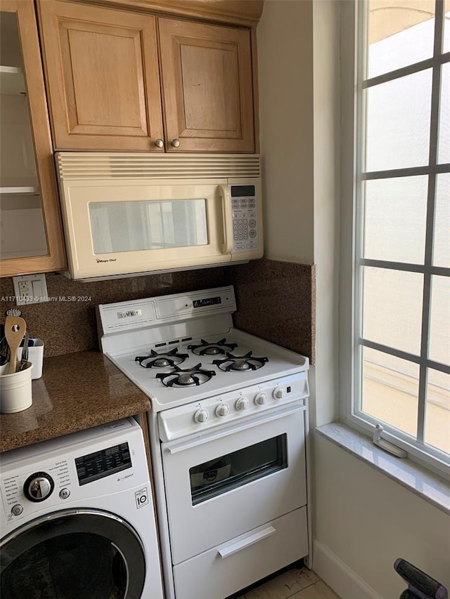 kitchen featuring washer / dryer and white appliances