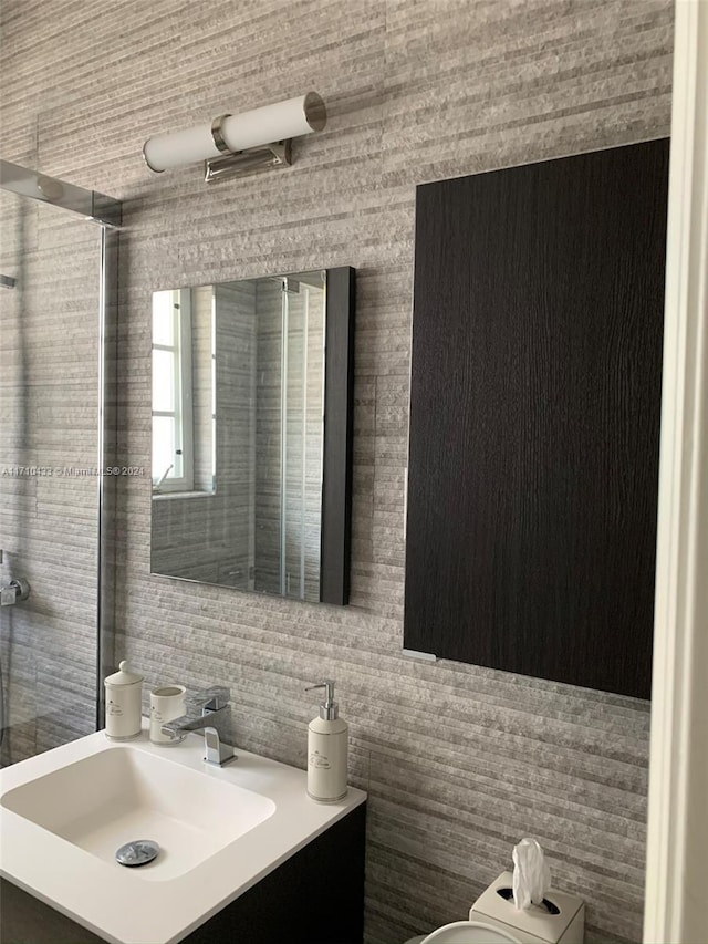 bathroom featuring vanity and tile walls