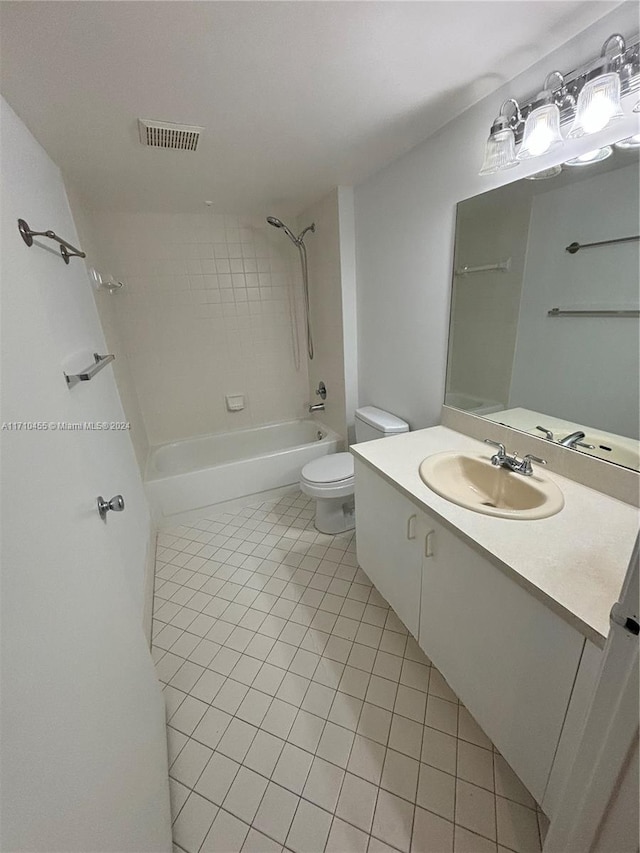 full bathroom featuring vanity, tile patterned flooring, tiled shower / bath, and toilet