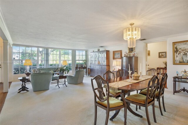 carpeted dining room featuring ornamental molding and a notable chandelier