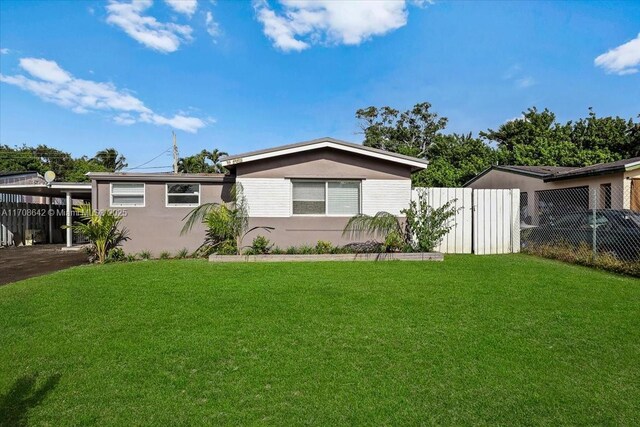 view of front of property with a carport and a front yard