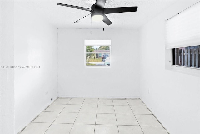 tiled empty room with a textured ceiling and ceiling fan