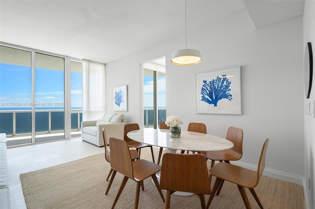 dining area featuring a water view and a wall of windows