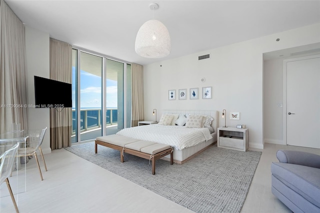 bedroom featuring access to outside and a wall of windows