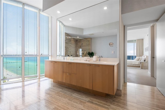 bathroom featuring vanity, a wall of windows, and a shower with shower door