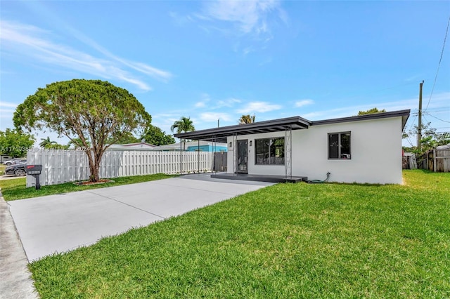 rear view of house featuring a lawn and a carport