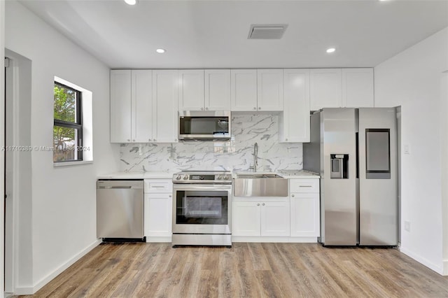 kitchen featuring white cabinets, stainless steel appliances, light hardwood / wood-style floors, and sink