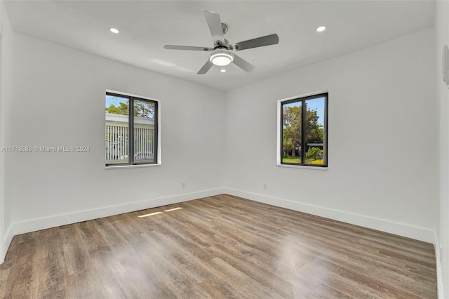 spare room featuring hardwood / wood-style flooring, ceiling fan, and a healthy amount of sunlight