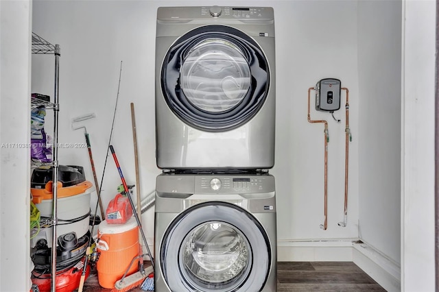 laundry area with dark hardwood / wood-style flooring and stacked washer / dryer