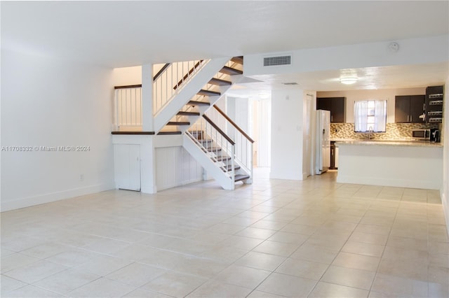 unfurnished living room with light tile patterned flooring