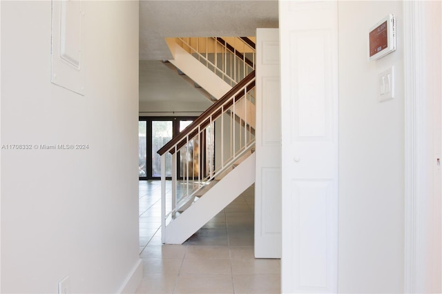 stairs featuring tile patterned floors and french doors