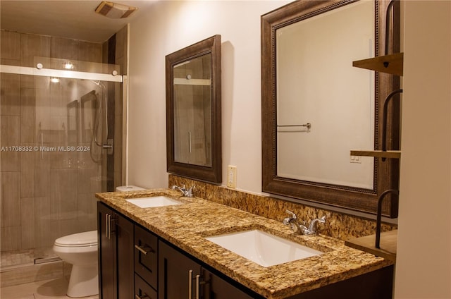 bathroom with tile patterned floors, vanity, toilet, and a shower with door