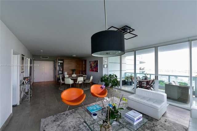 living room with a wall of windows and dark wood-type flooring