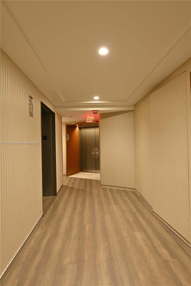 corridor with hardwood / wood-style floors