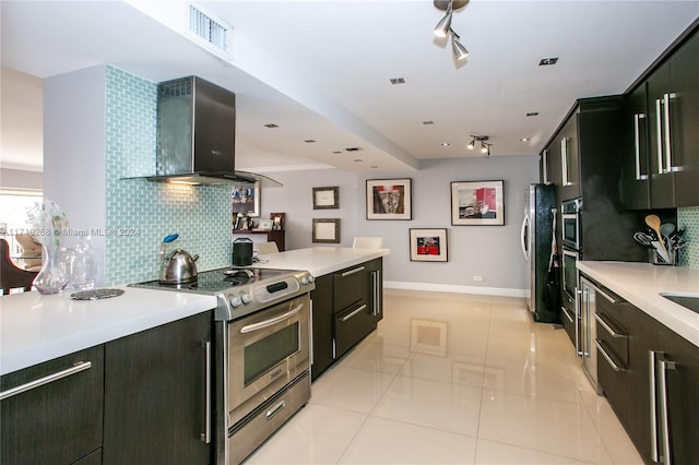 kitchen with tasteful backsplash, light tile patterned floors, wall chimney range hood, and appliances with stainless steel finishes