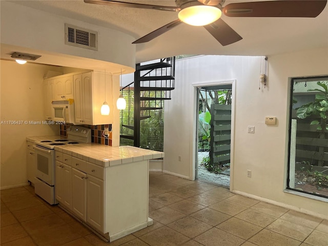 kitchen featuring tile countertops, white cabinetry, white appliances, and a wealth of natural light