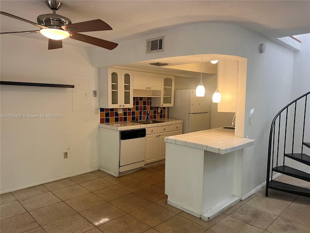 kitchen with pendant lighting, white appliances, backsplash, tile counters, and white cabinetry