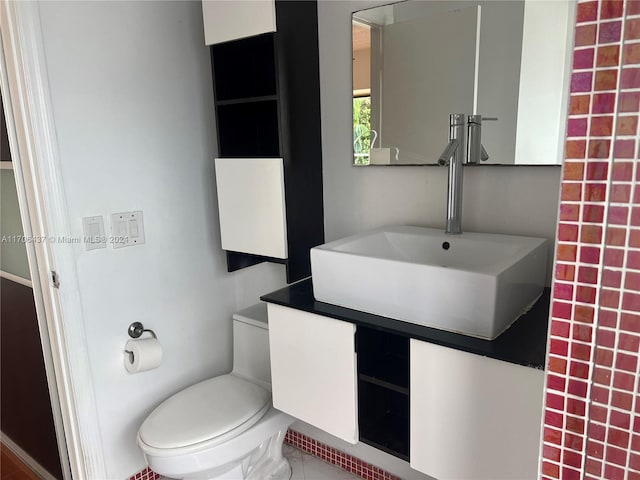 bathroom with tile patterned flooring, vanity, and toilet