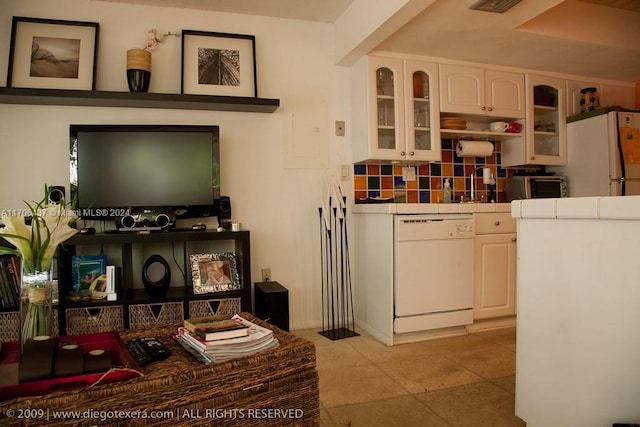 kitchen featuring white cabinets, sink, white appliances, and backsplash