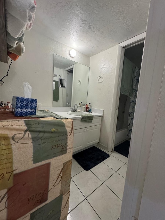 bathroom featuring tile patterned flooring, vanity, and a textured ceiling