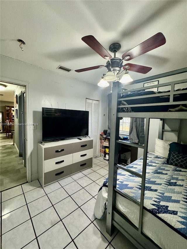 bedroom featuring ceiling fan, a closet, and light tile patterned flooring