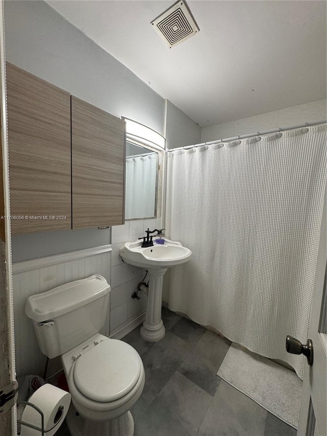 bathroom featuring toilet and a shower with shower curtain