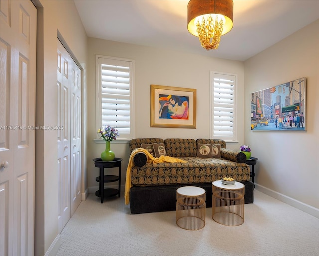 sitting room featuring carpet floors and a notable chandelier