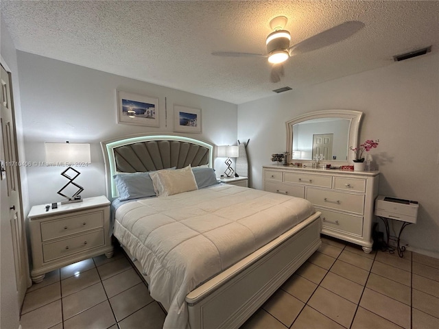 bedroom featuring tile patterned floors, ceiling fan, and a textured ceiling