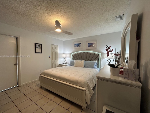 tiled bedroom featuring a textured ceiling and ceiling fan