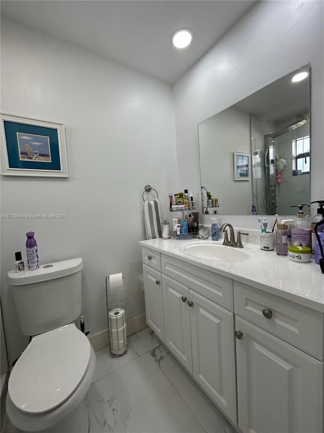 bathroom with tiled shower, vanity, and toilet