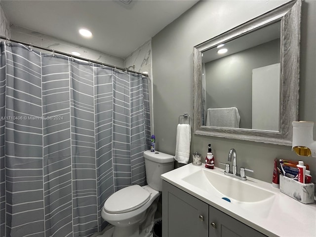 bathroom featuring vanity, curtained shower, and toilet