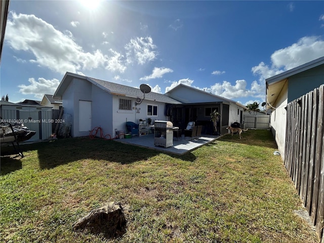 rear view of property featuring a patio and a lawn