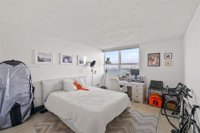 bedroom featuring light tile patterned floors and a textured ceiling