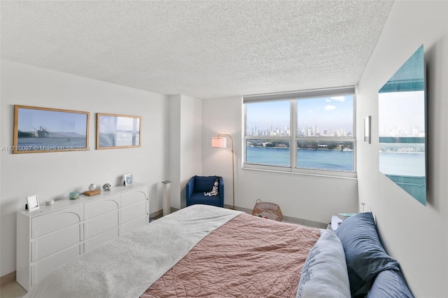 bedroom with a textured ceiling and a water view