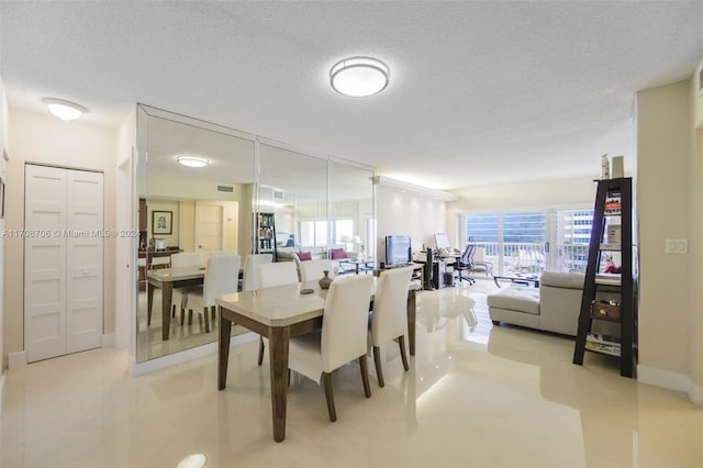 dining room featuring light tile patterned flooring and a textured ceiling