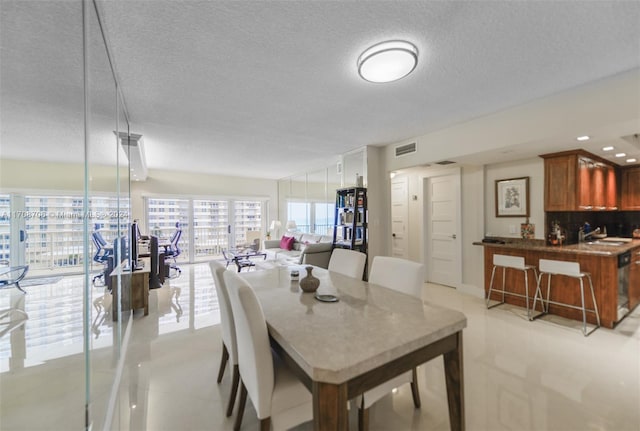 dining space with sink and a textured ceiling