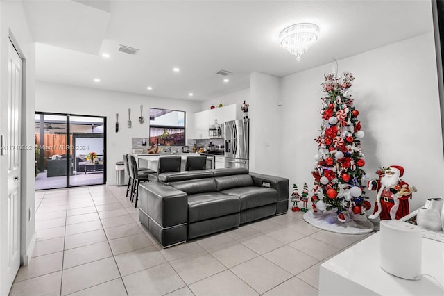 living room featuring light tile patterned floors and a chandelier