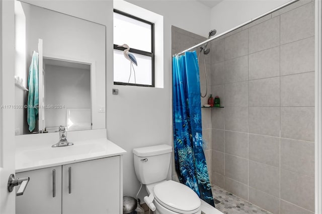 bathroom featuring a shower with shower curtain, vanity, and toilet