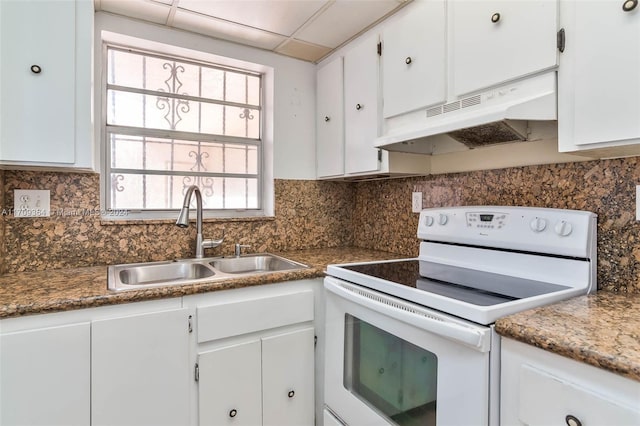 kitchen featuring white range with electric stovetop, white cabinetry, a drop ceiling, and a healthy amount of sunlight