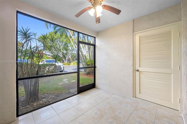 unfurnished sunroom featuring ceiling fan