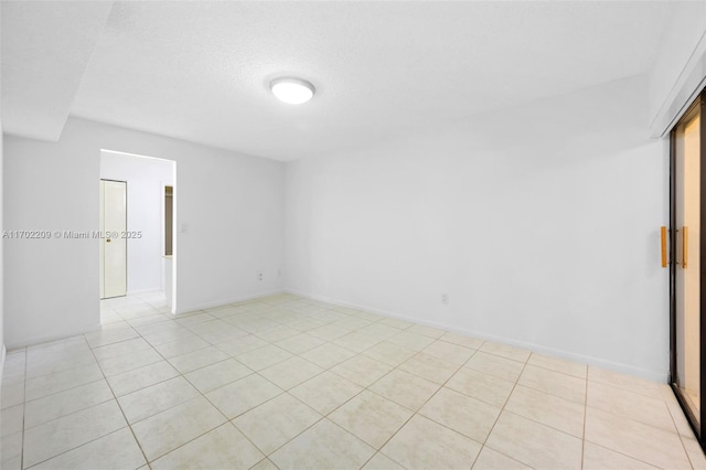 tiled spare room featuring a textured ceiling