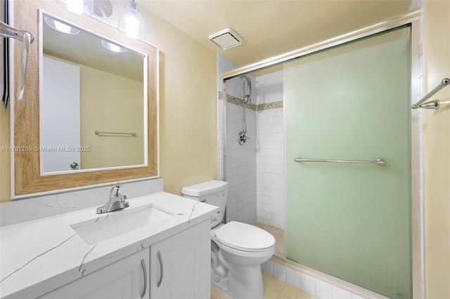 bathroom with vanity, a shower with shower door, and toilet