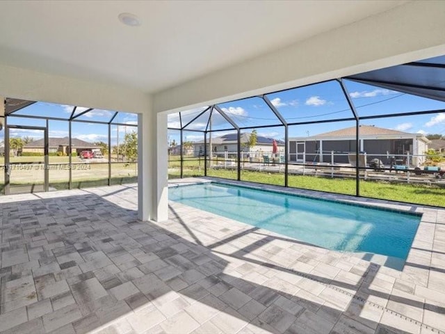 view of swimming pool with glass enclosure and a patio area