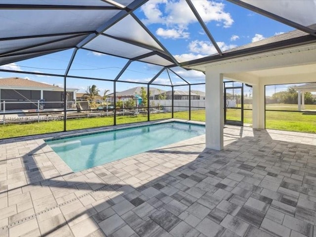 view of swimming pool featuring a lawn, glass enclosure, and a patio