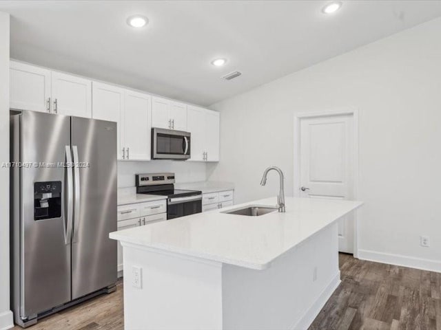 kitchen with appliances with stainless steel finishes, a center island with sink, white cabinetry, and dark hardwood / wood-style floors