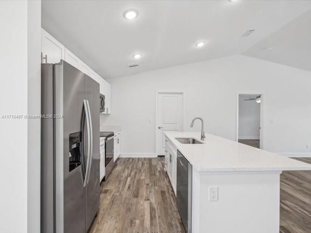 kitchen featuring sink, an island with sink, vaulted ceiling, white cabinets, and appliances with stainless steel finishes