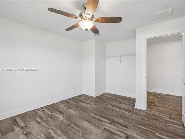 unfurnished bedroom featuring ceiling fan, dark hardwood / wood-style floors, and a closet